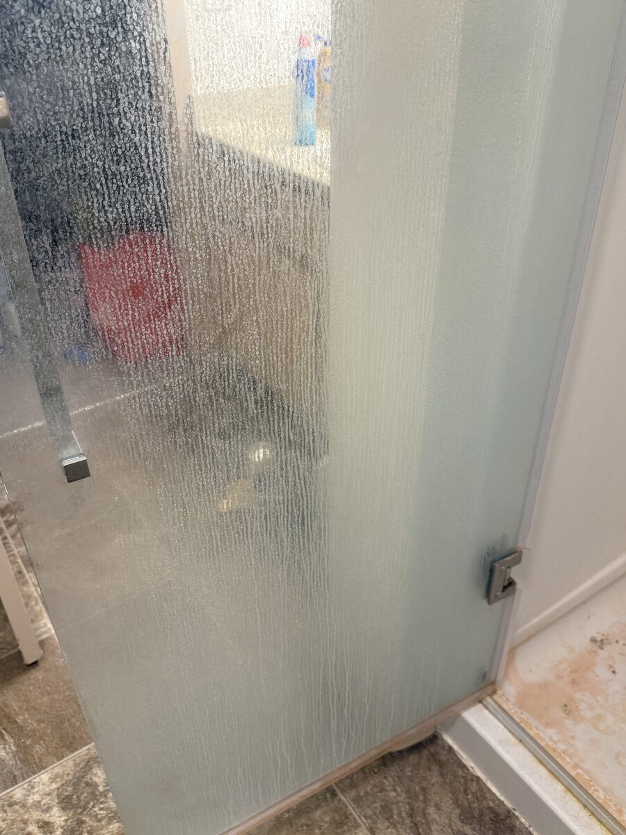 Glass shower door before cleaning